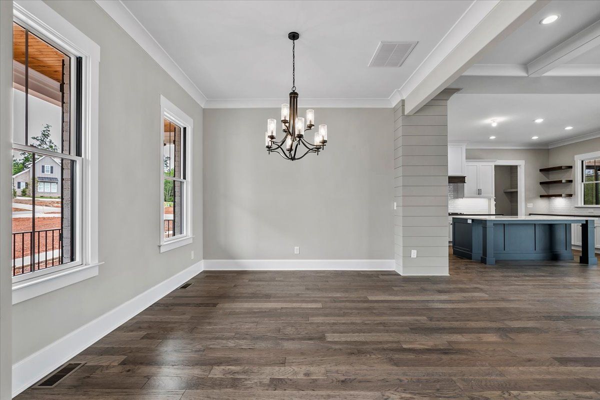 A chandelier hanging from the ceiling of an empty room