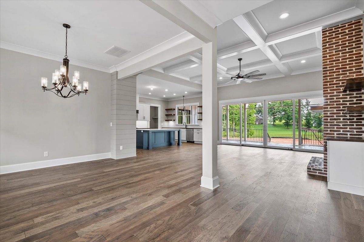 An open floor room with hardwood floors and a chandelier
