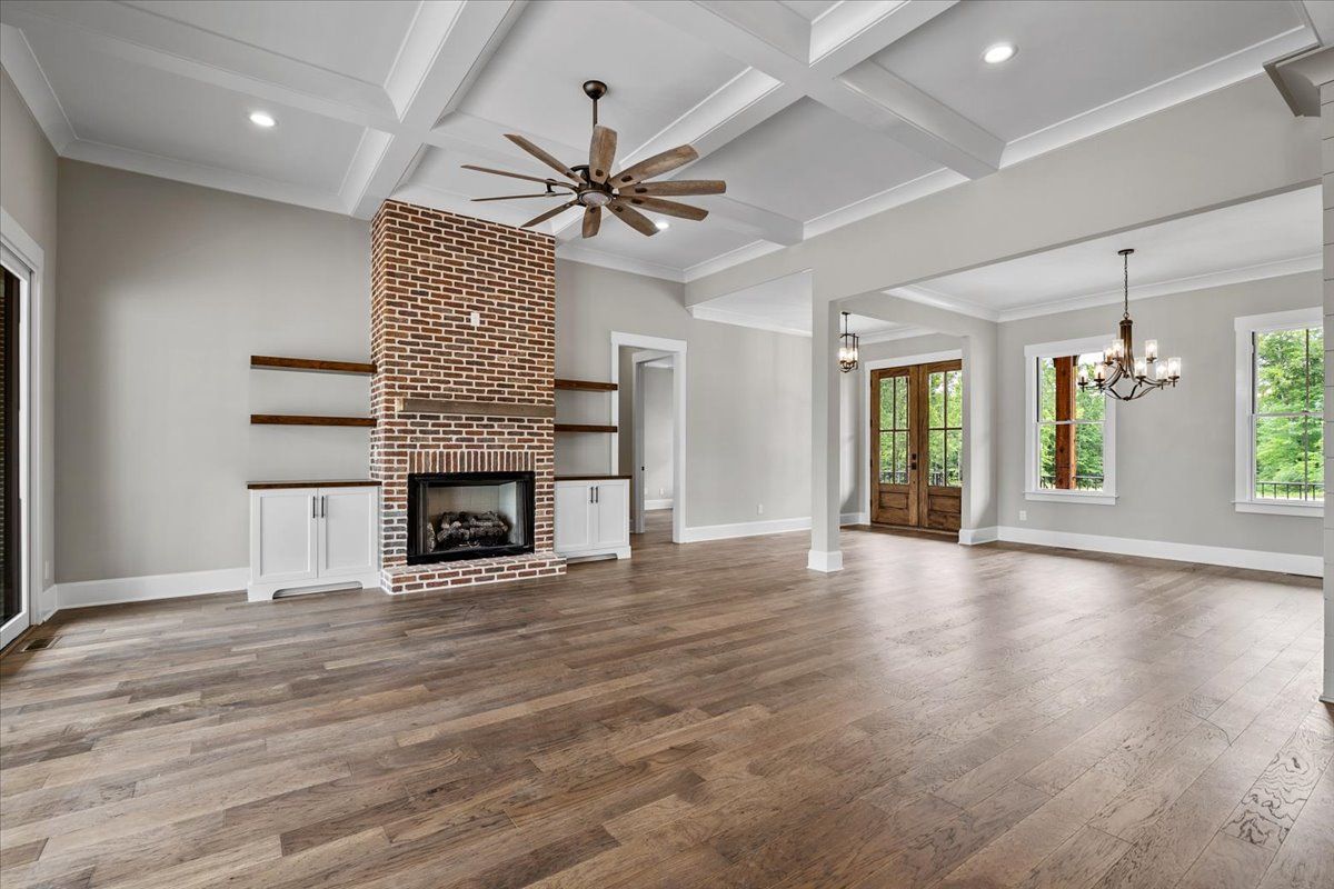 An empty living room with a brick fireplace