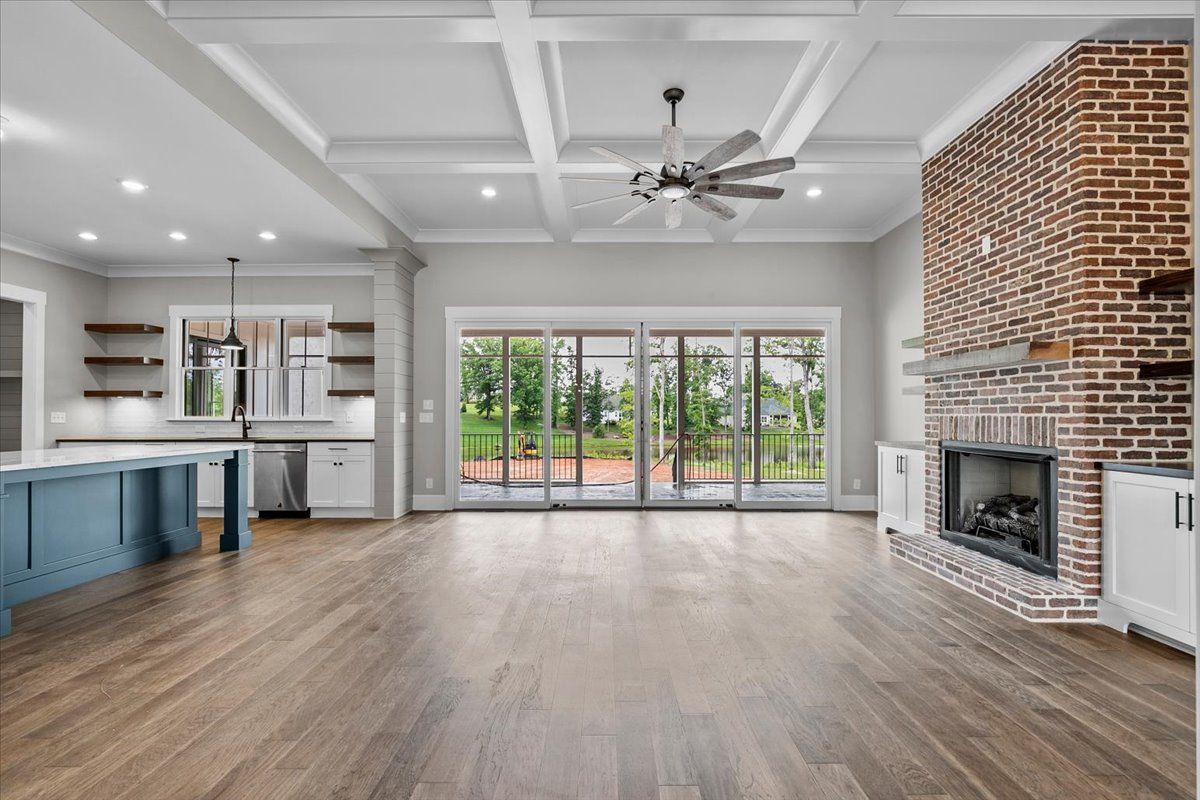 An empty living room with a fireplace and sliding glass doors