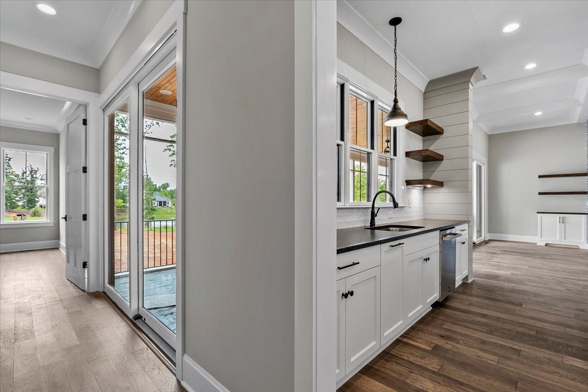A kitchen with a sink, dishwasher, and sliding glass doors