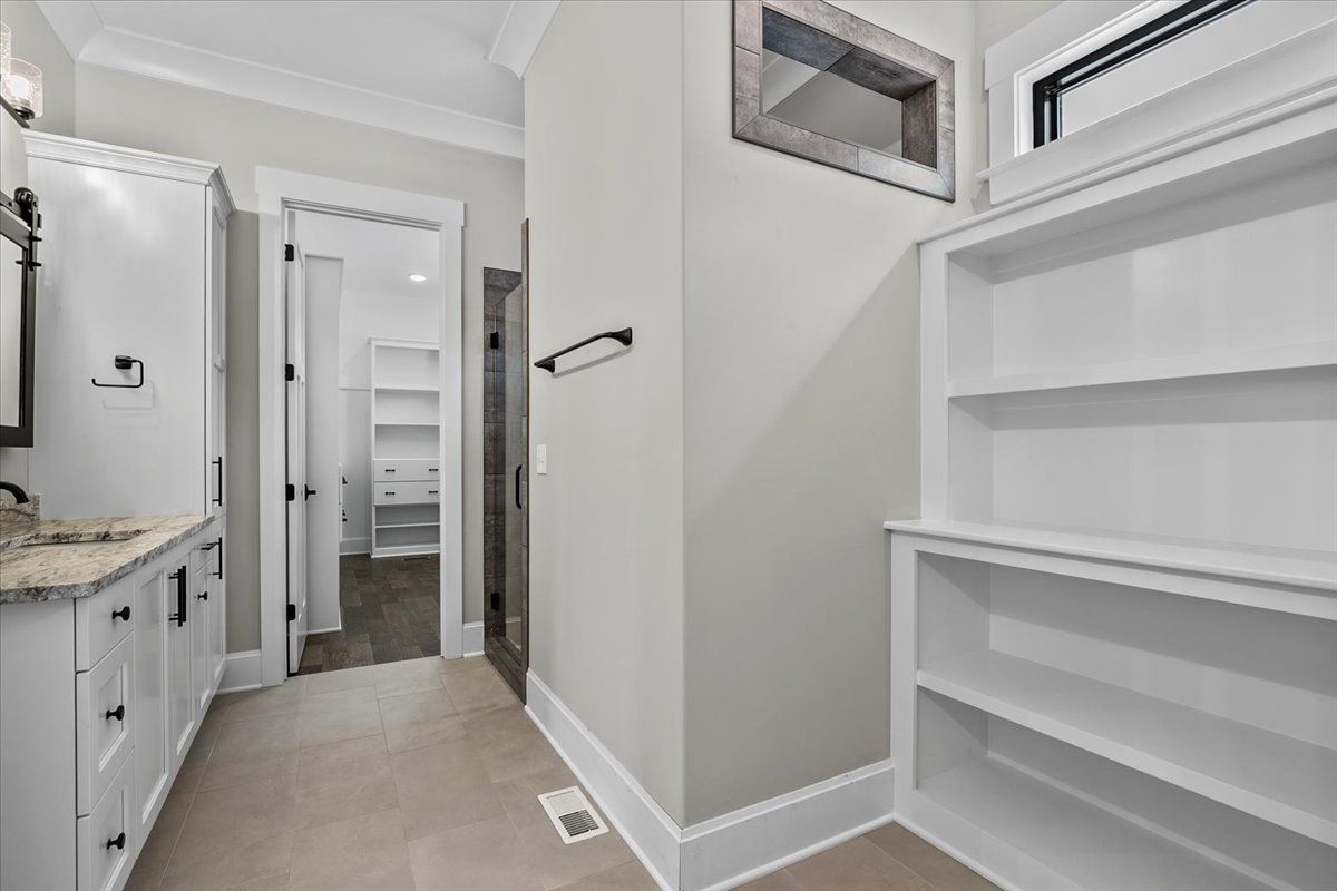 A bathroom with a sink and empty shelves