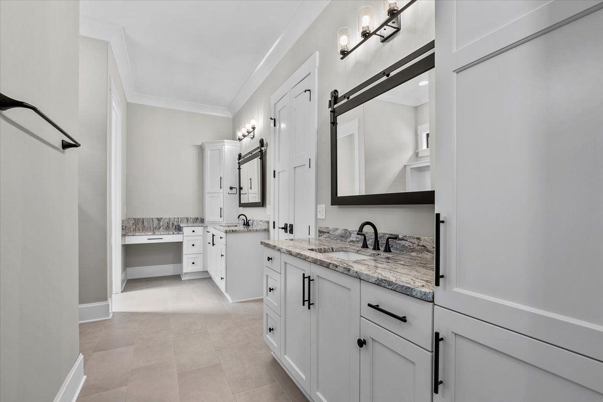 A bathroom with two sinks and white cabinets