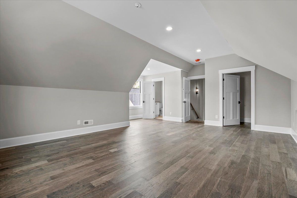 A large empty room with hardwood floors and gray walls