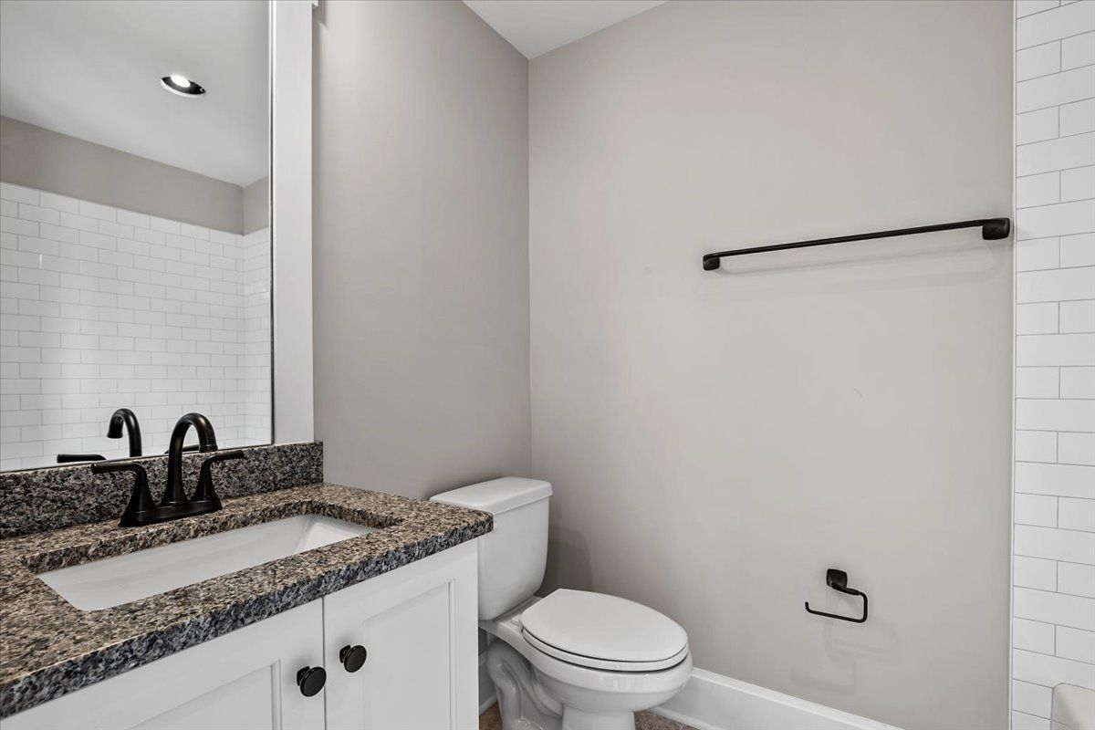 A bathroom with a sink, toilet, and mirror