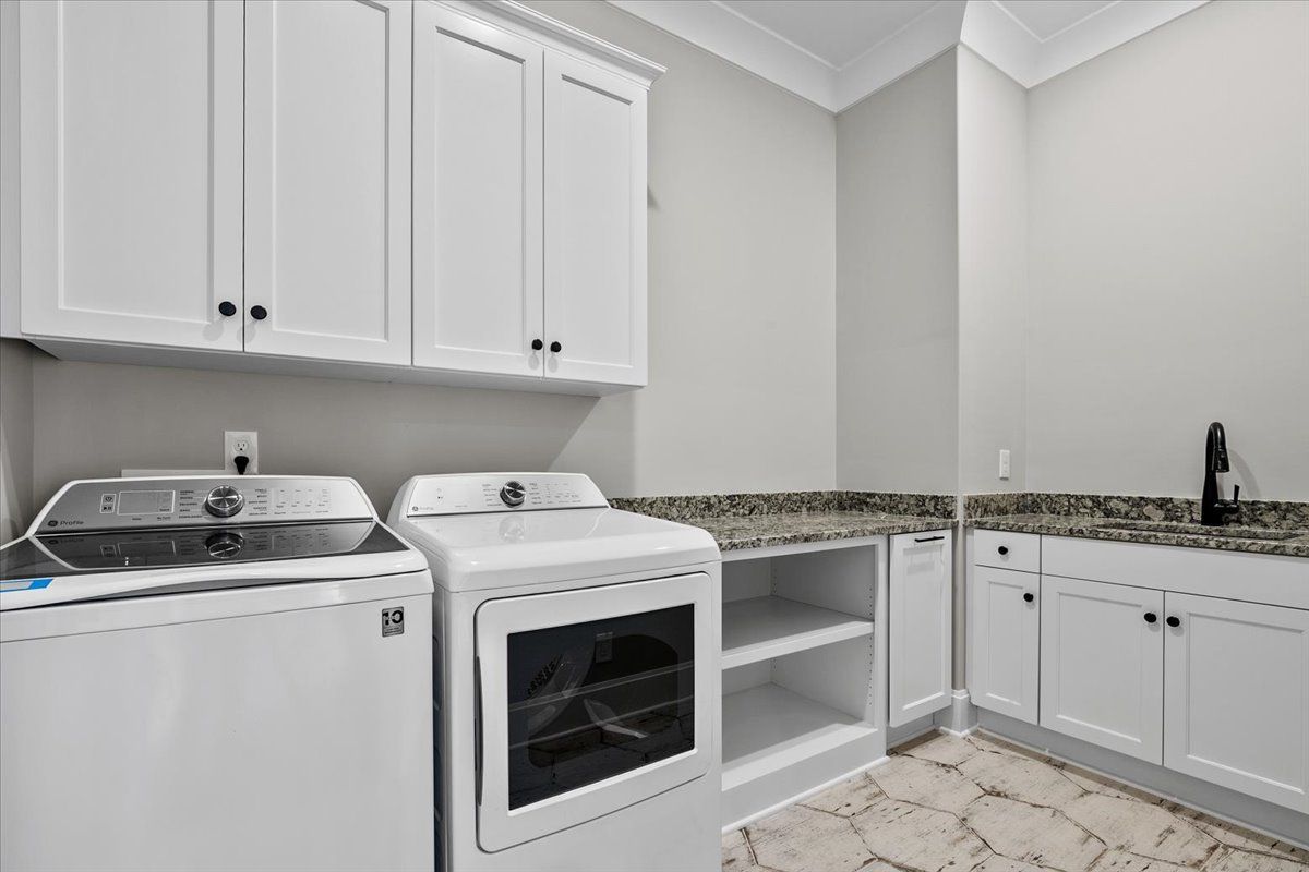 A laundry room with a washer, dryer, and a sink