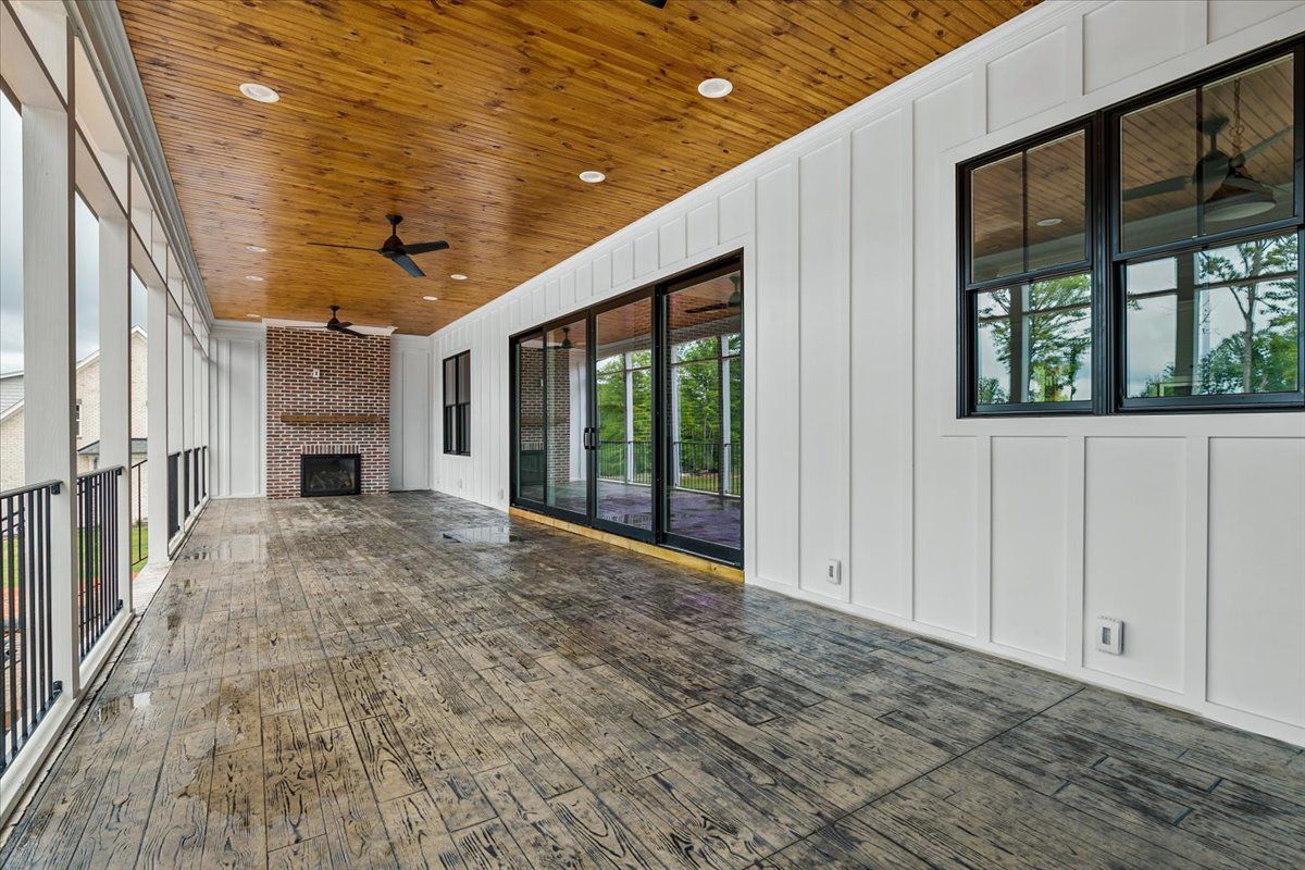 A large porch with a wooden ceiling and sliding glass doors