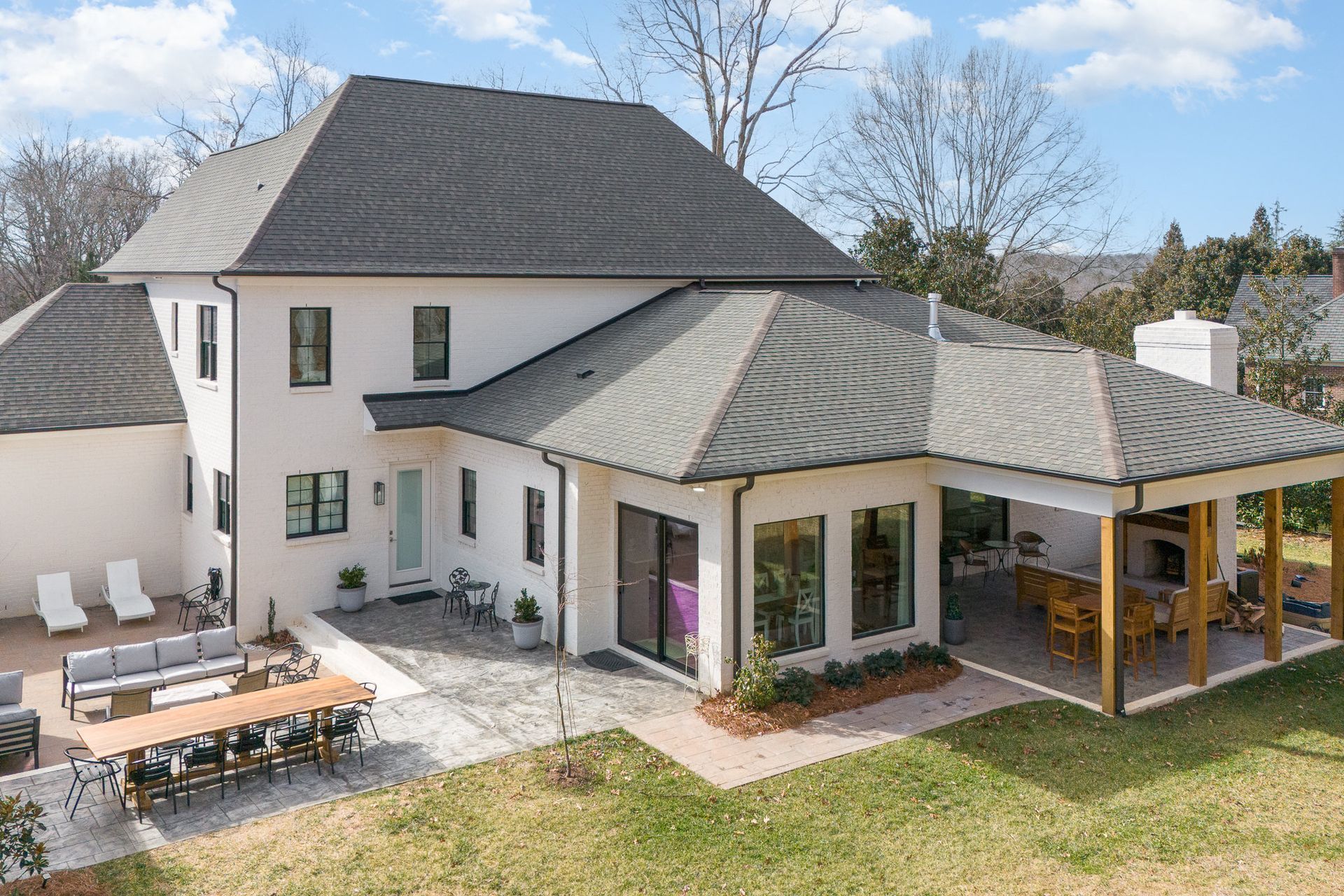 An aerial view of a large white house with a large patio area