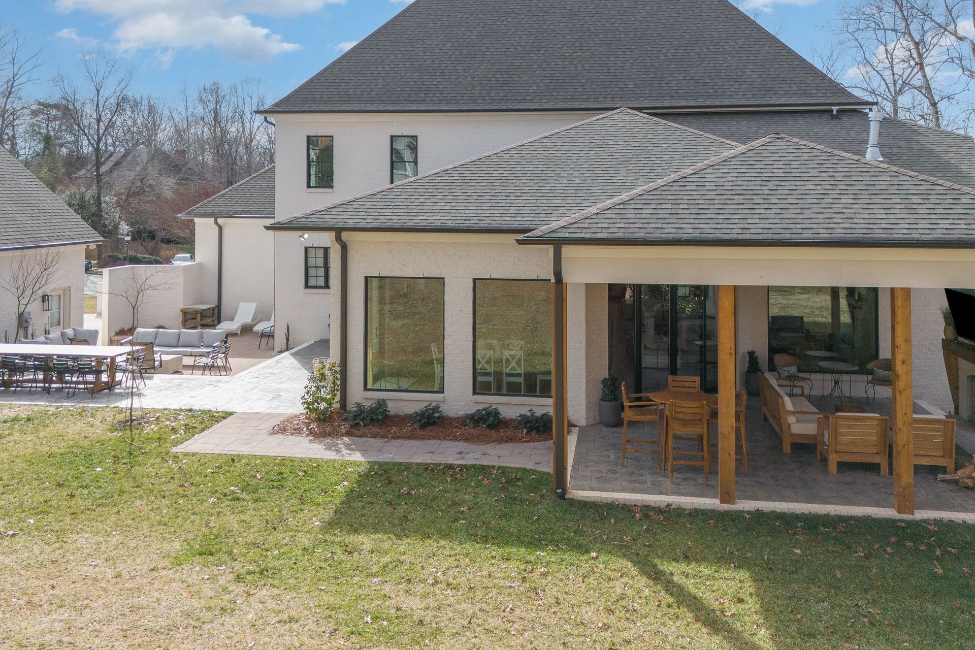 A large white house with a covered patio in the backyard