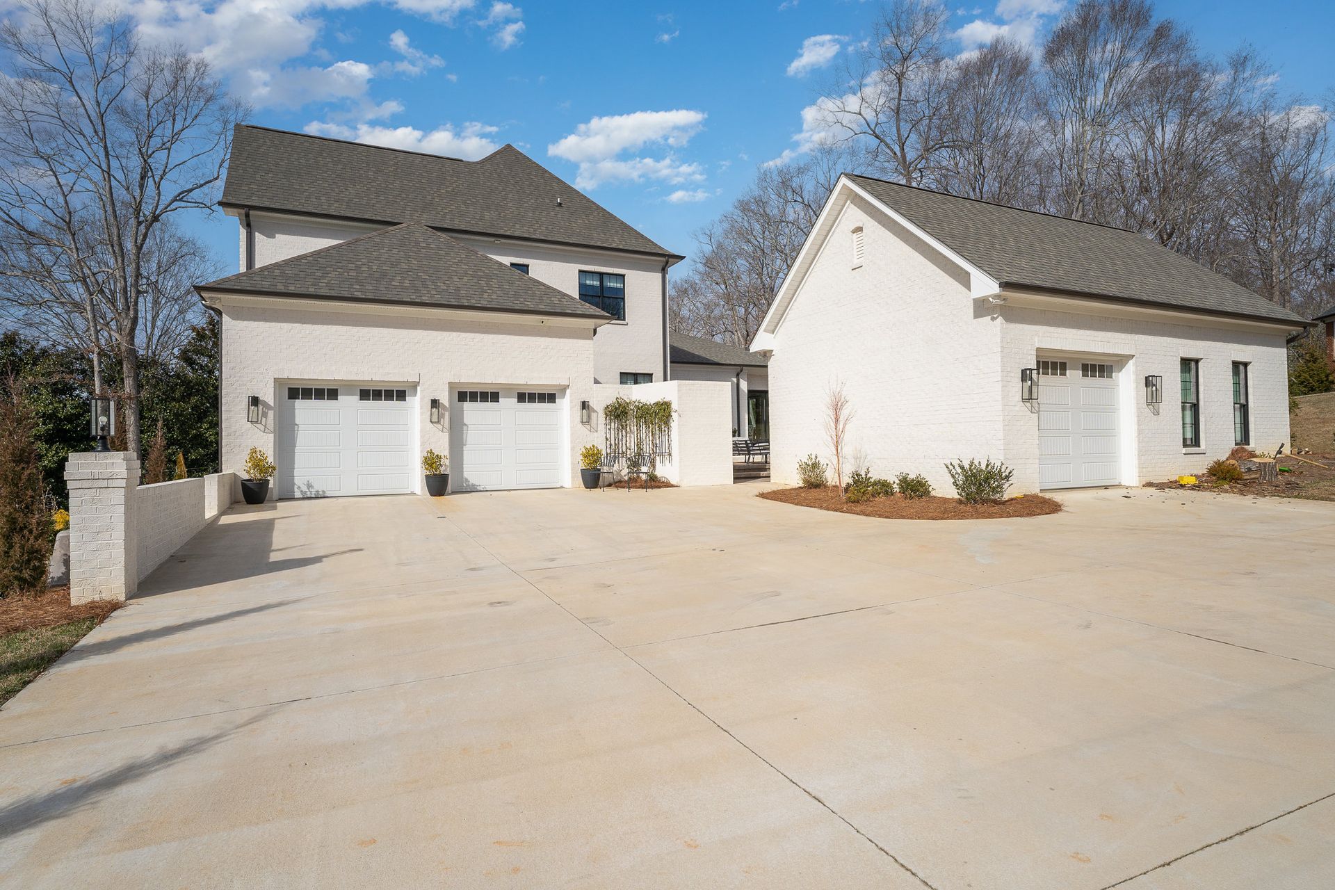 A large white house with three garages and a large driveway