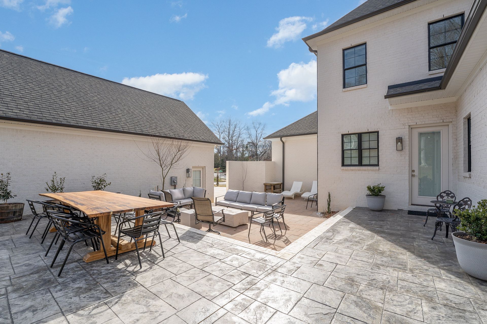 A large white house with a patio area with a table and chairs