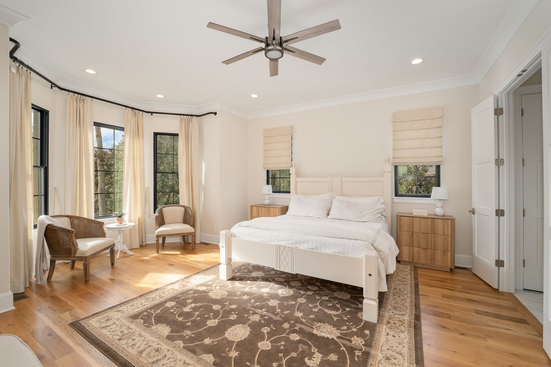 Master's bedroom with chairs, rug, and ceiling fan