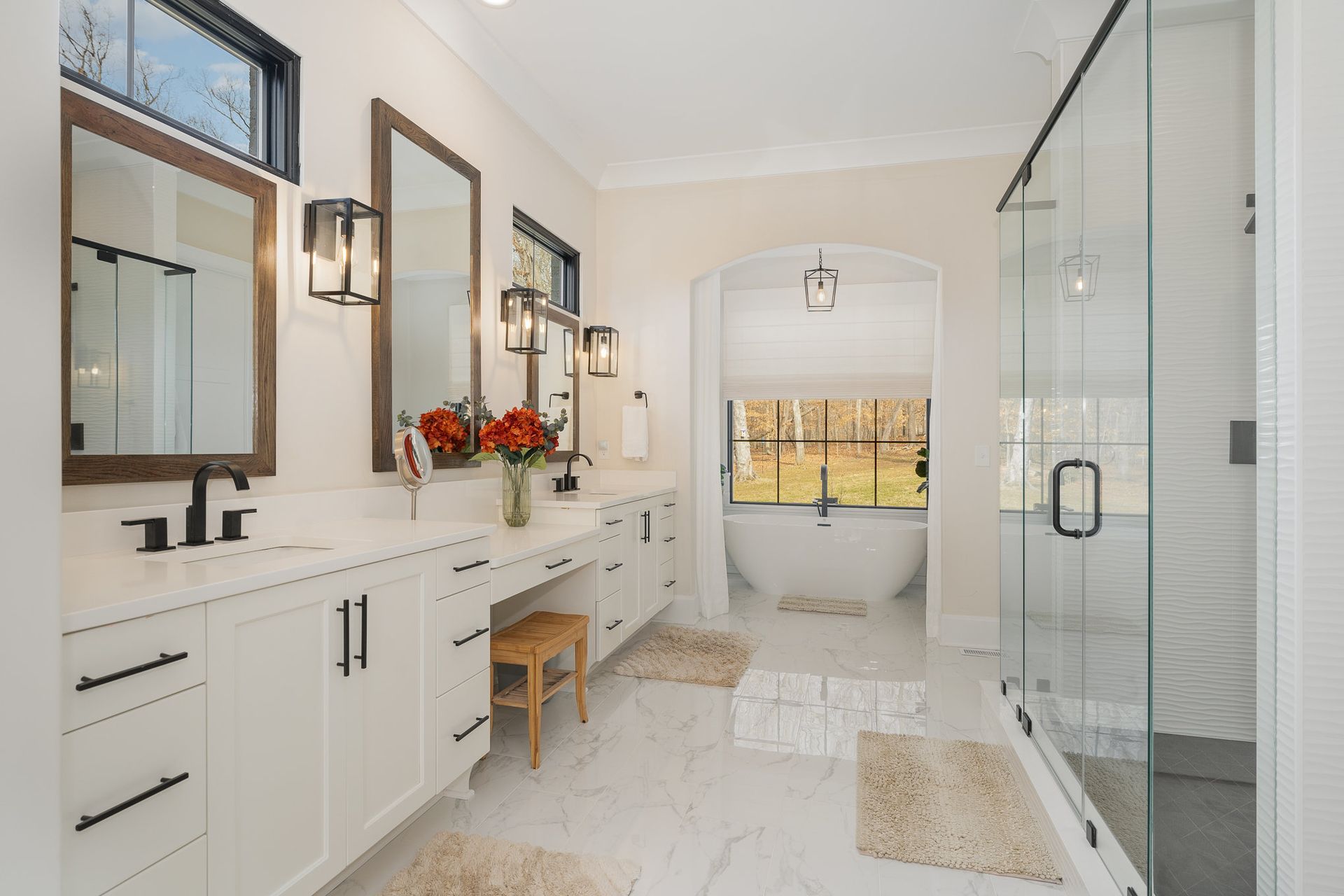 A bathroom with a tub, sink, mirrors, and a walk-in shower