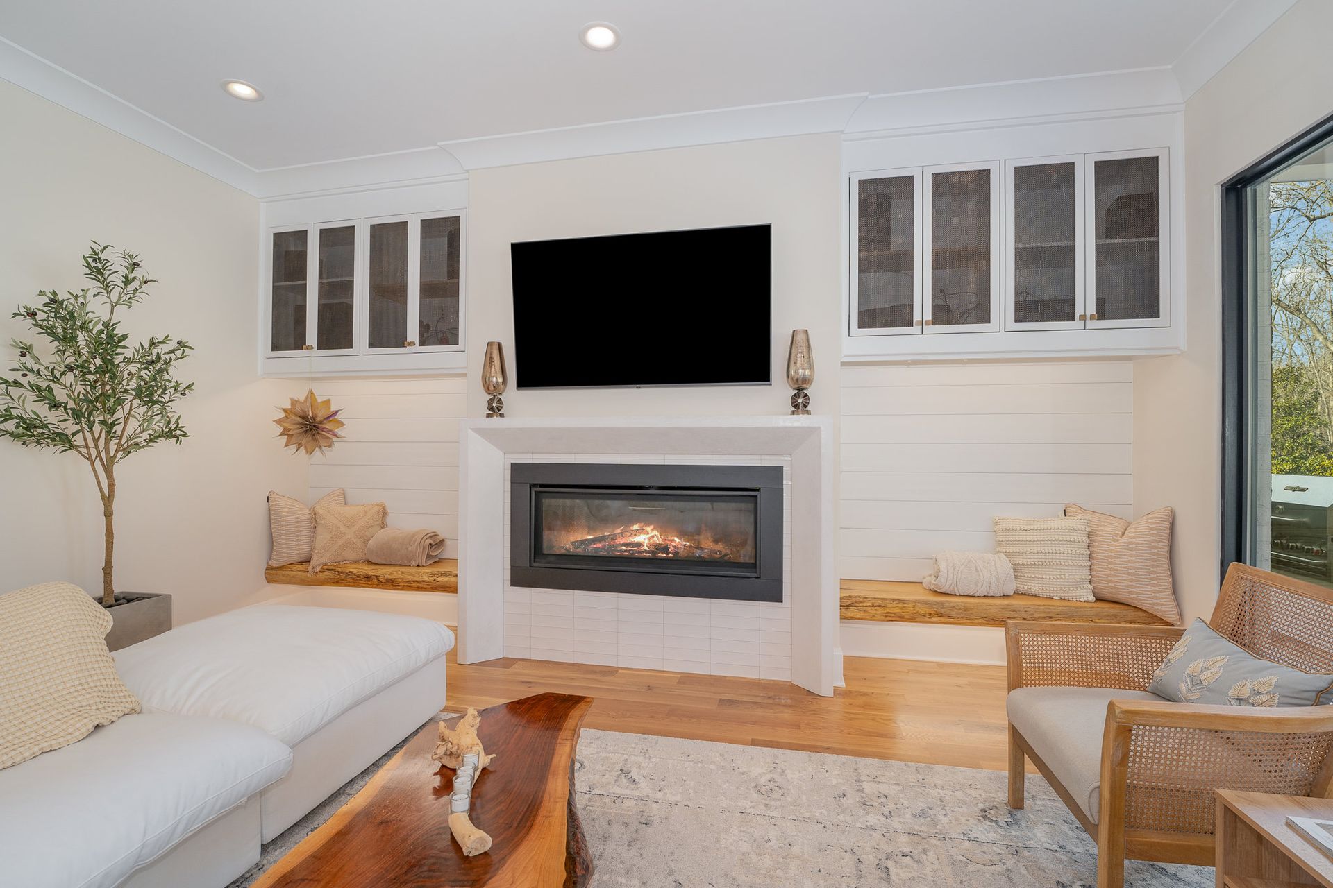 A living room with a fireplace and a flat-screen TV