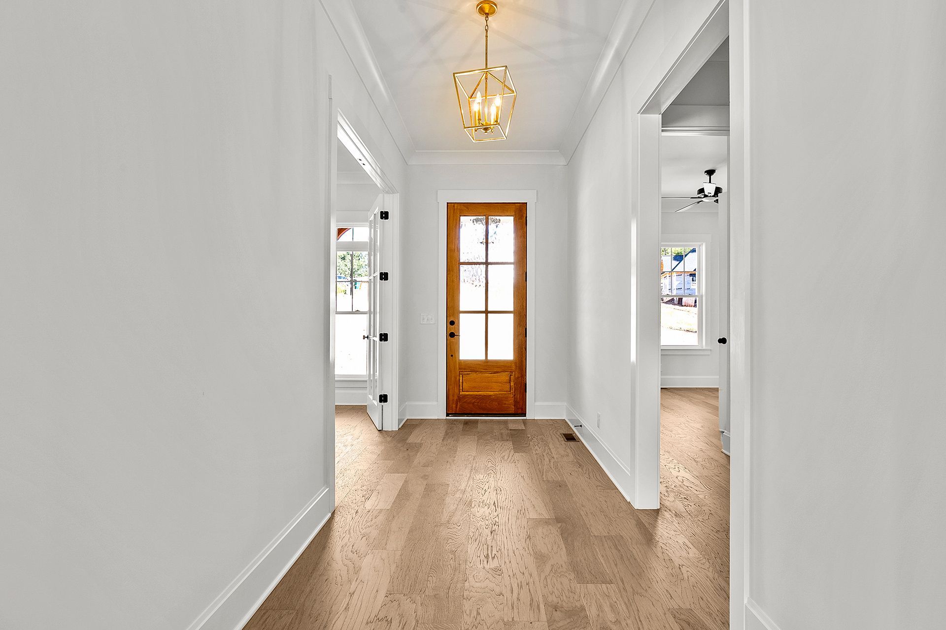 A hallway with hardwood floors and a wooden door