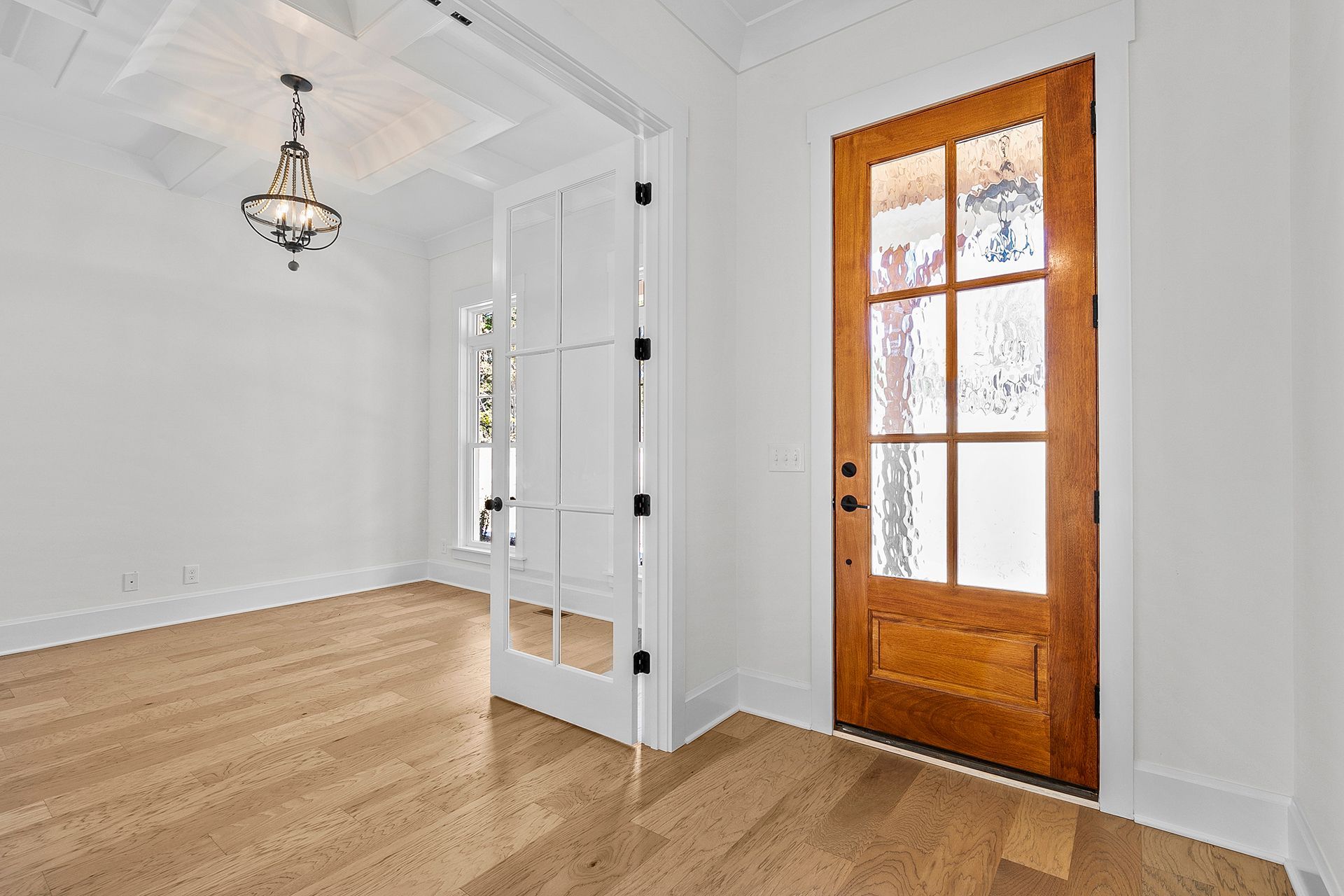 An empty room with hardwood floors and a wooden door