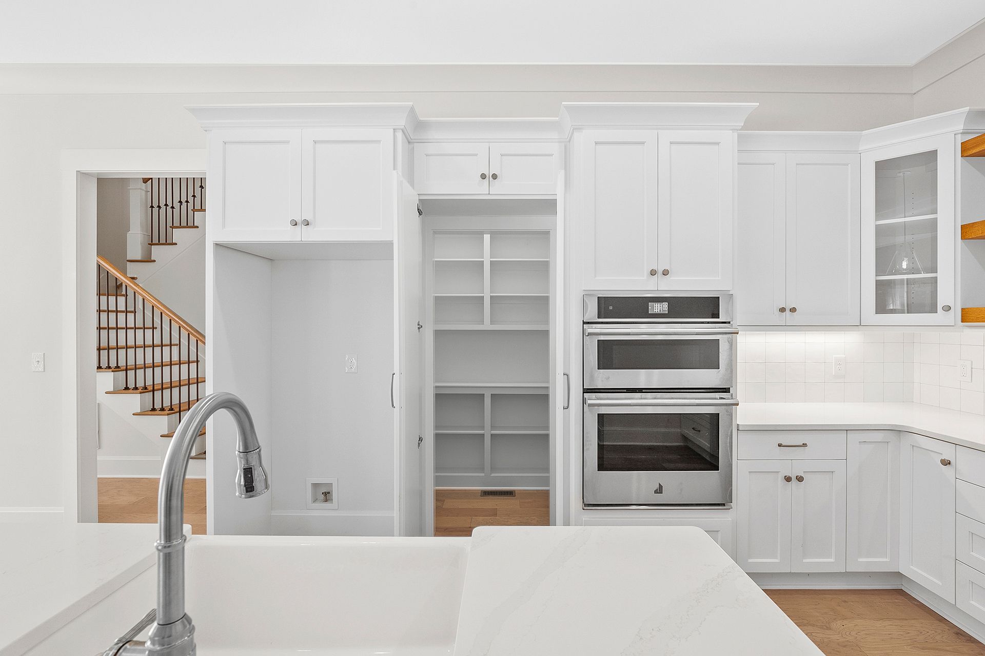 A kitchen with a door leading to a walk-in pantry
