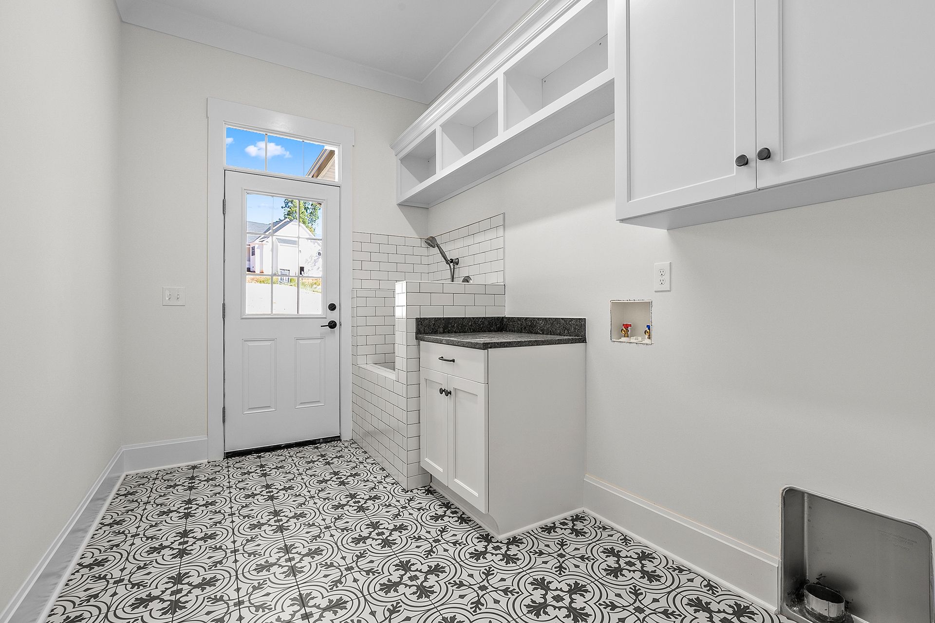 A laundry room with white cabinets