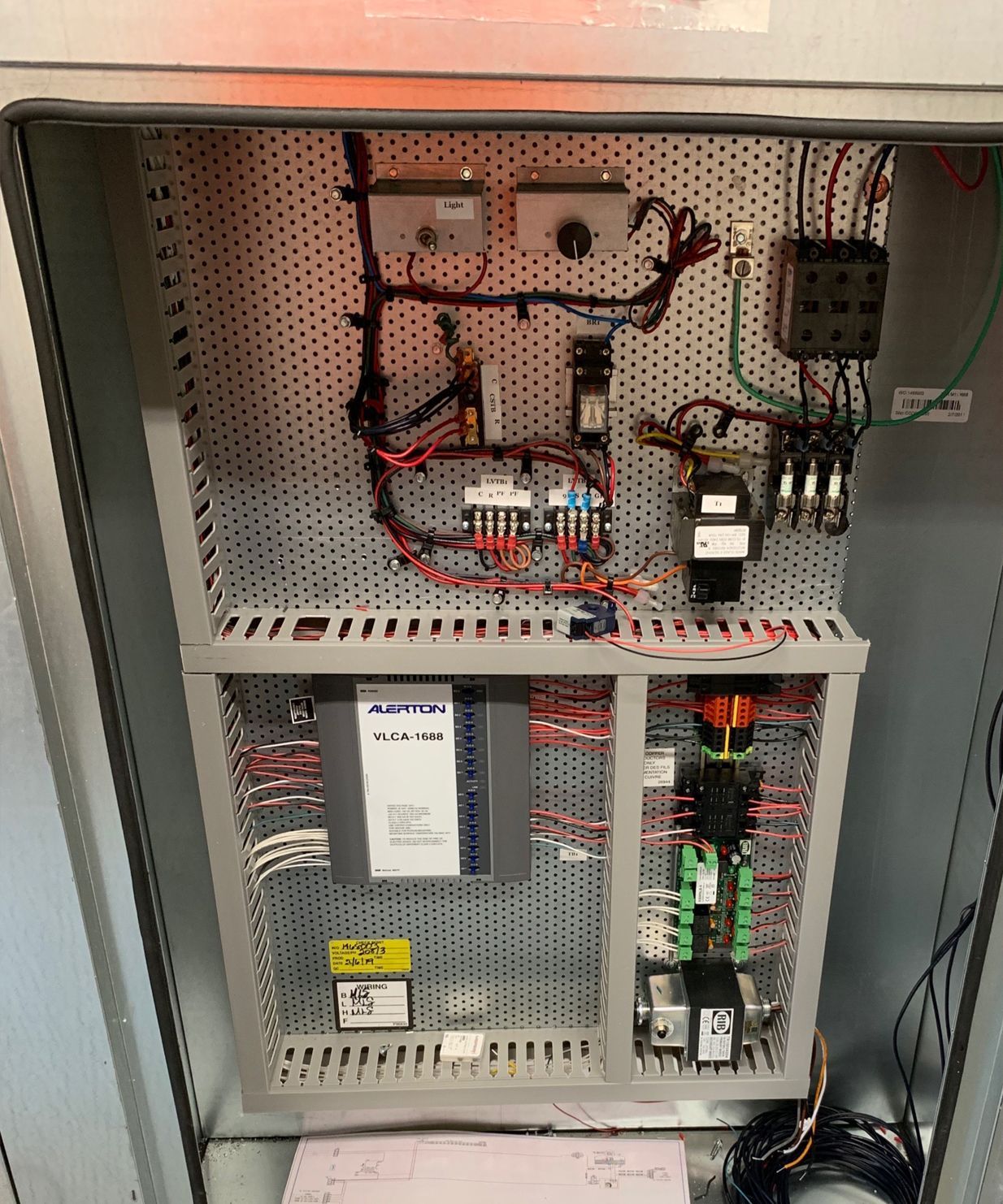 The inside of an electrical box with a lot of wires coming out of it