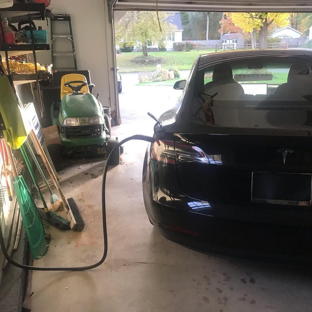 An electric car is being charged in a garage