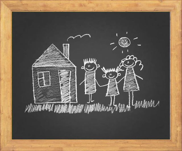 Chalk drawing on a black board showing a house, a sun, and three stick figures holding hands on a grassy field.