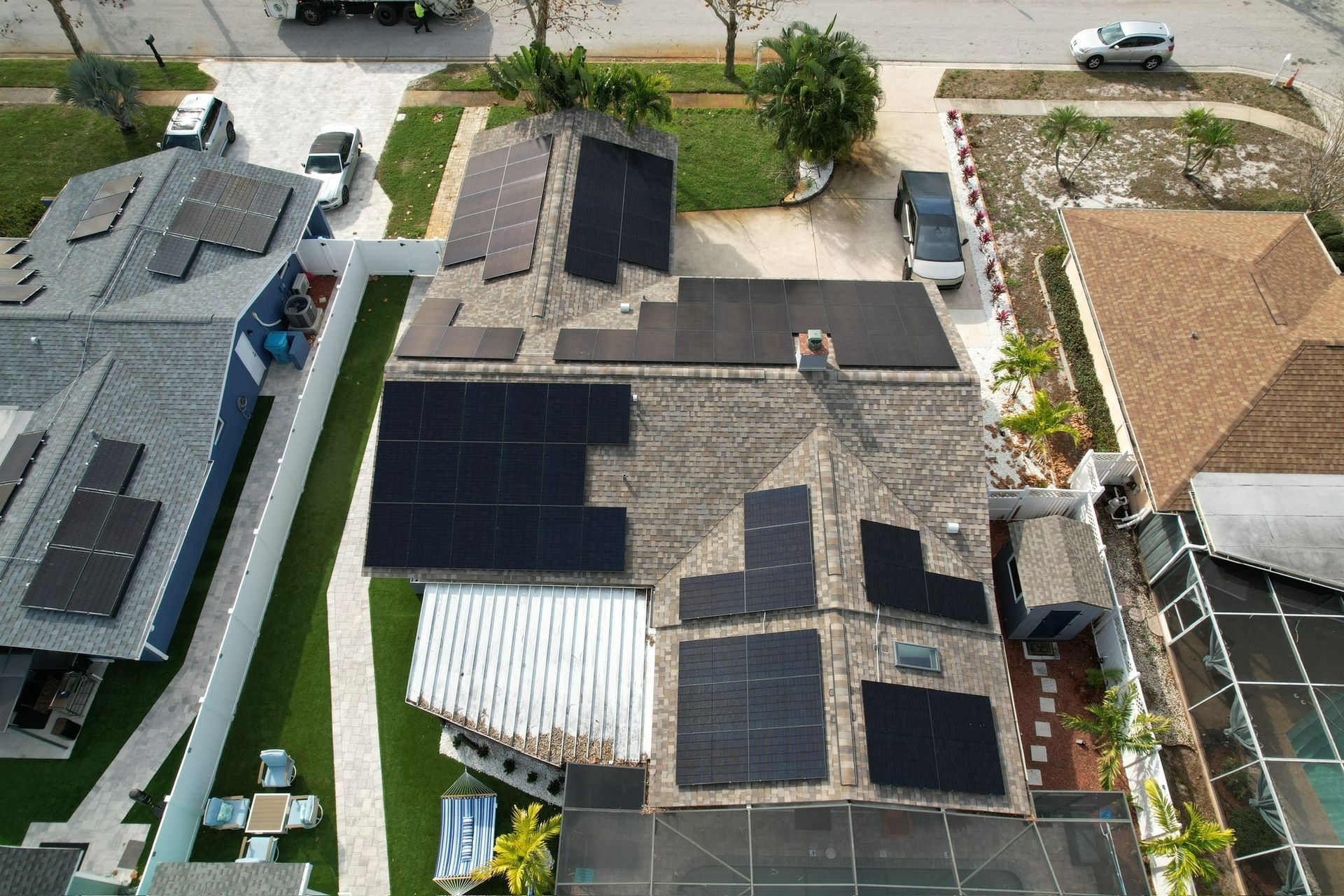 Aerial view of houses with solar panels on rooftops in a residential neighborhood.