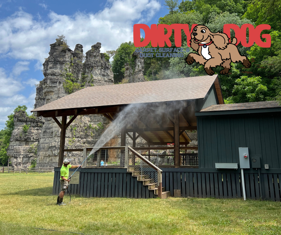 A man spraying a building with a dirty dog logo in the background
