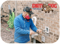 A man wearing a mask is cleaning a vent.