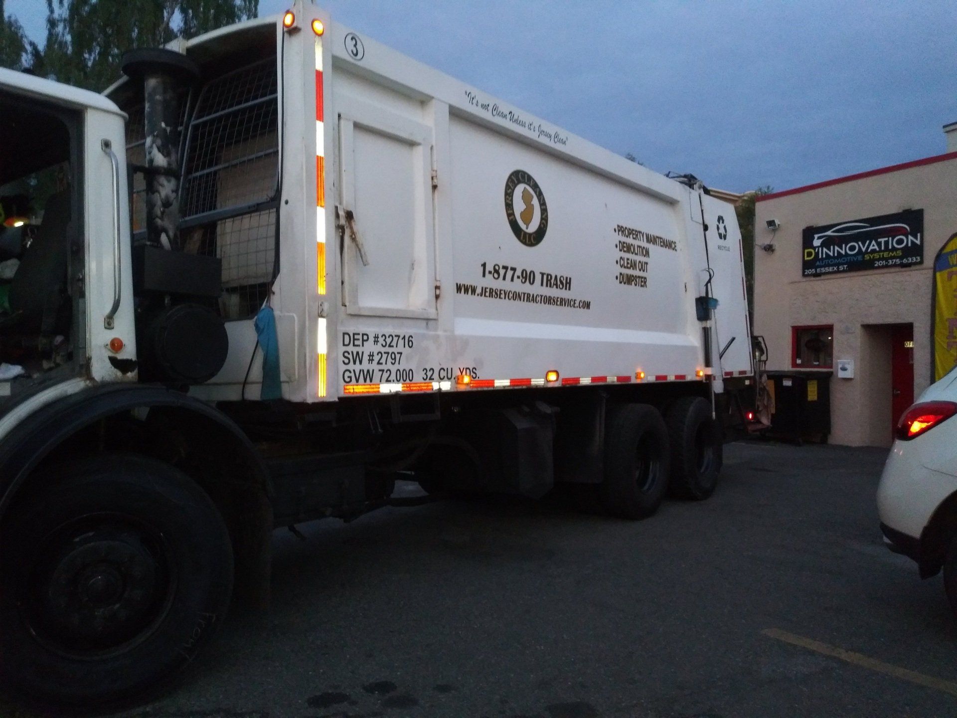 A garbage truck is parked in front of a building