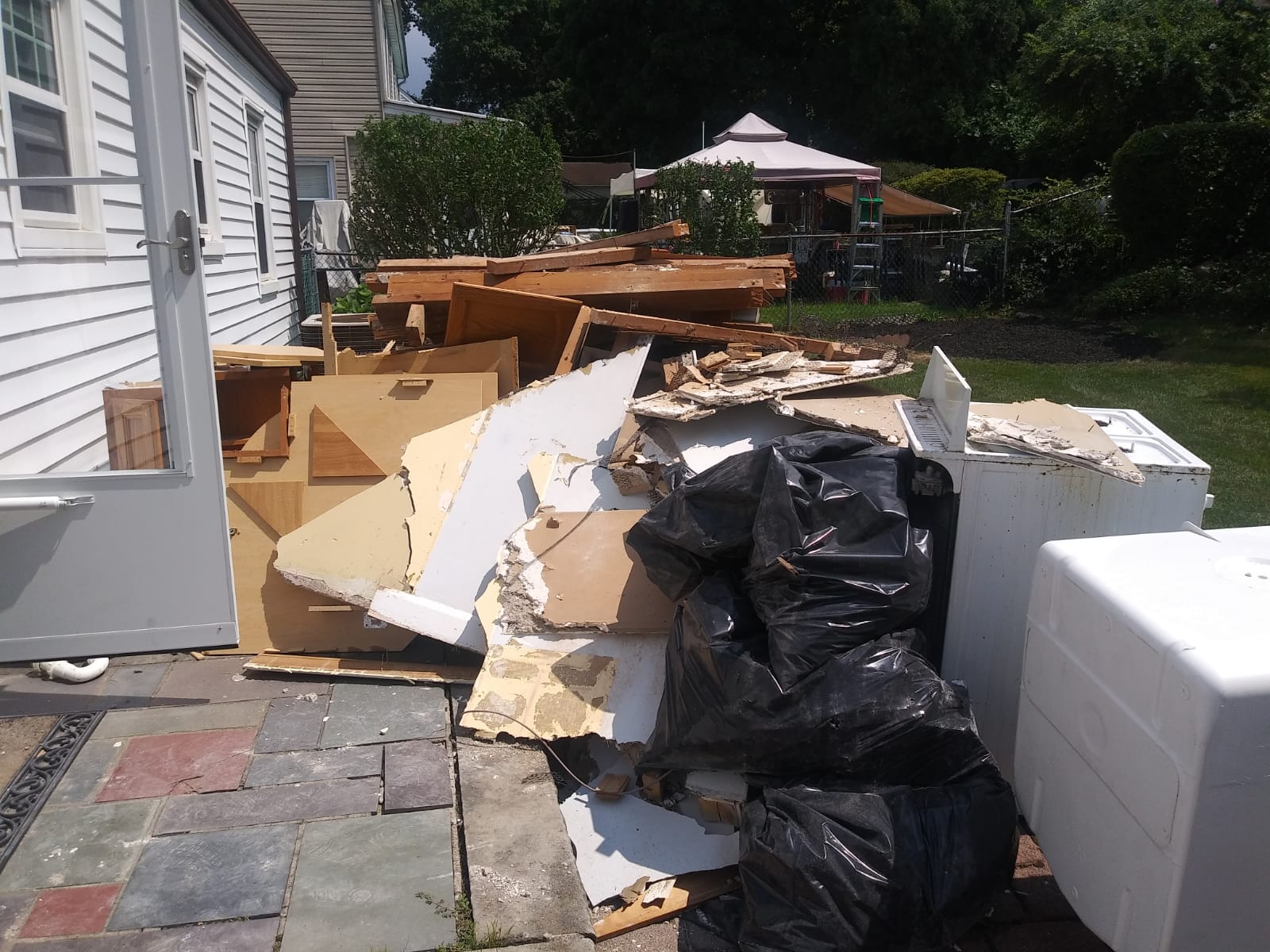 A pile of trash is sitting outside of a house