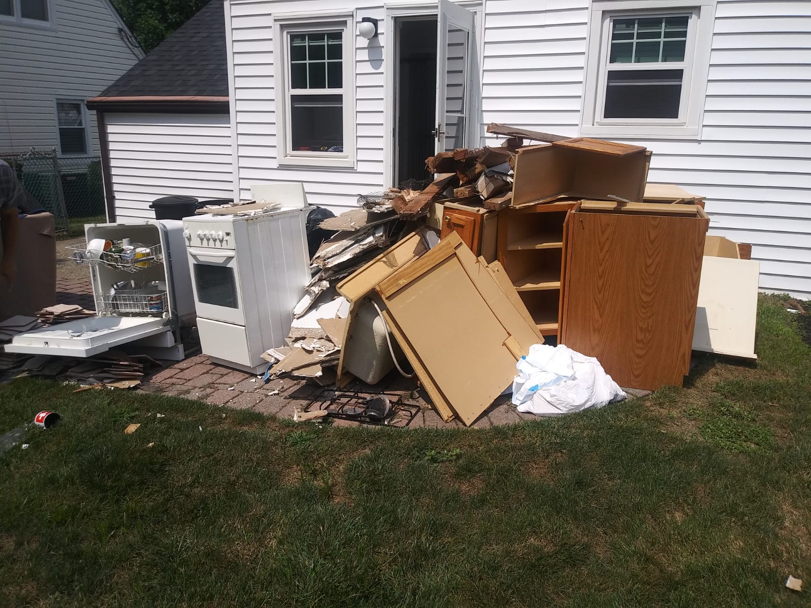 A pile of junk is sitting in front of a house.