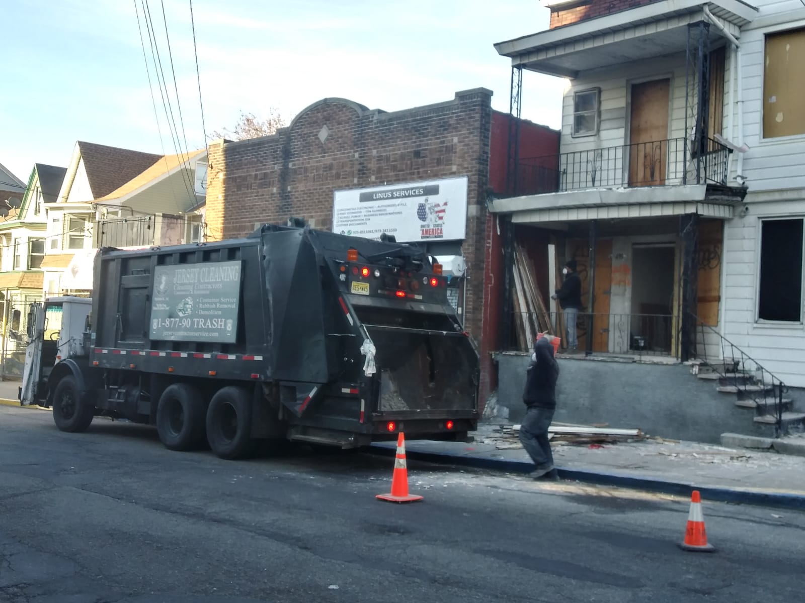 A garbage truck is parked on the side of the road