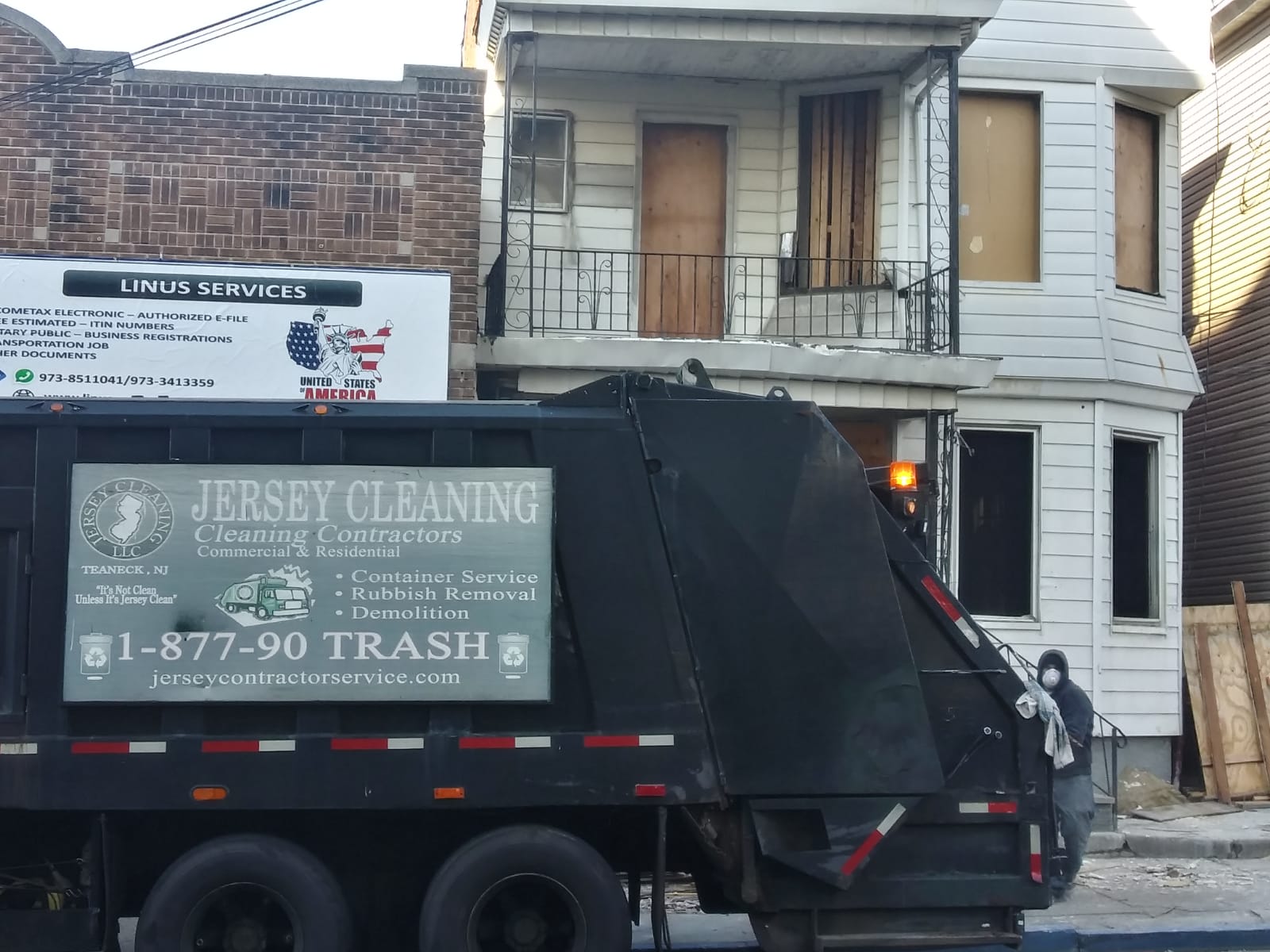 Jersey Cleaning garbage truck is parked in front of a house.