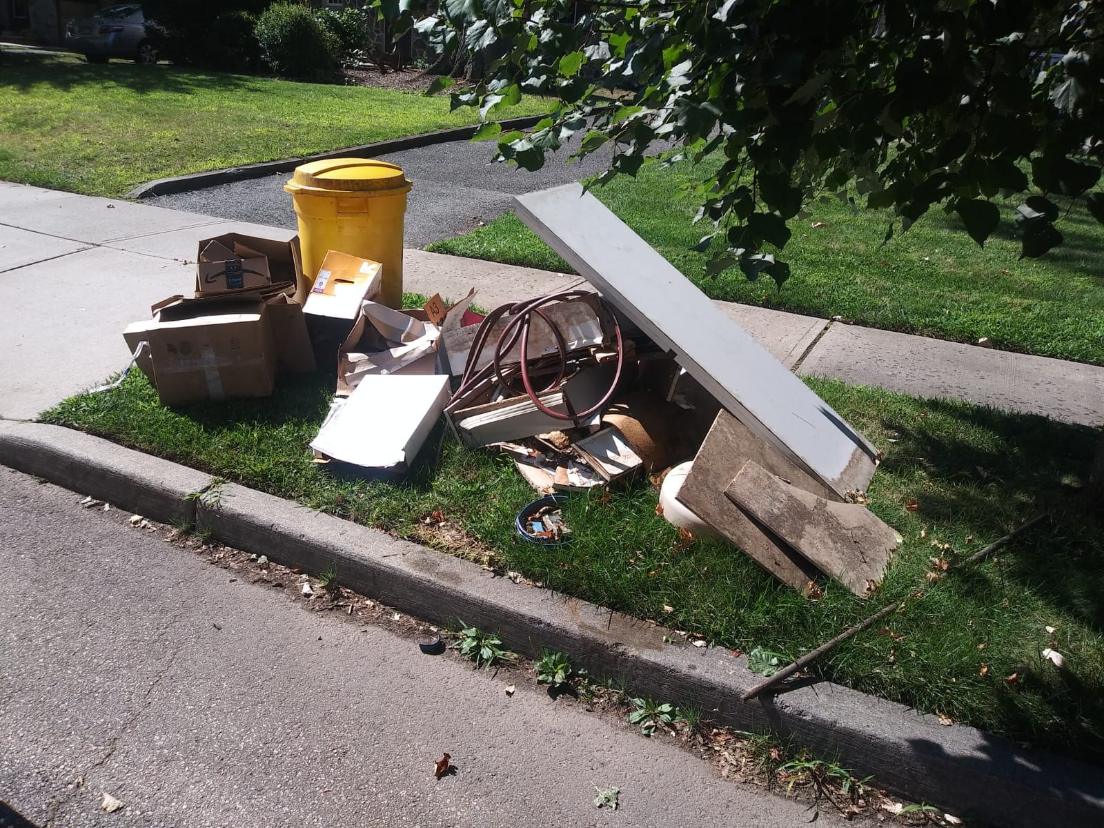 A pile of garbage is on the side of the road.