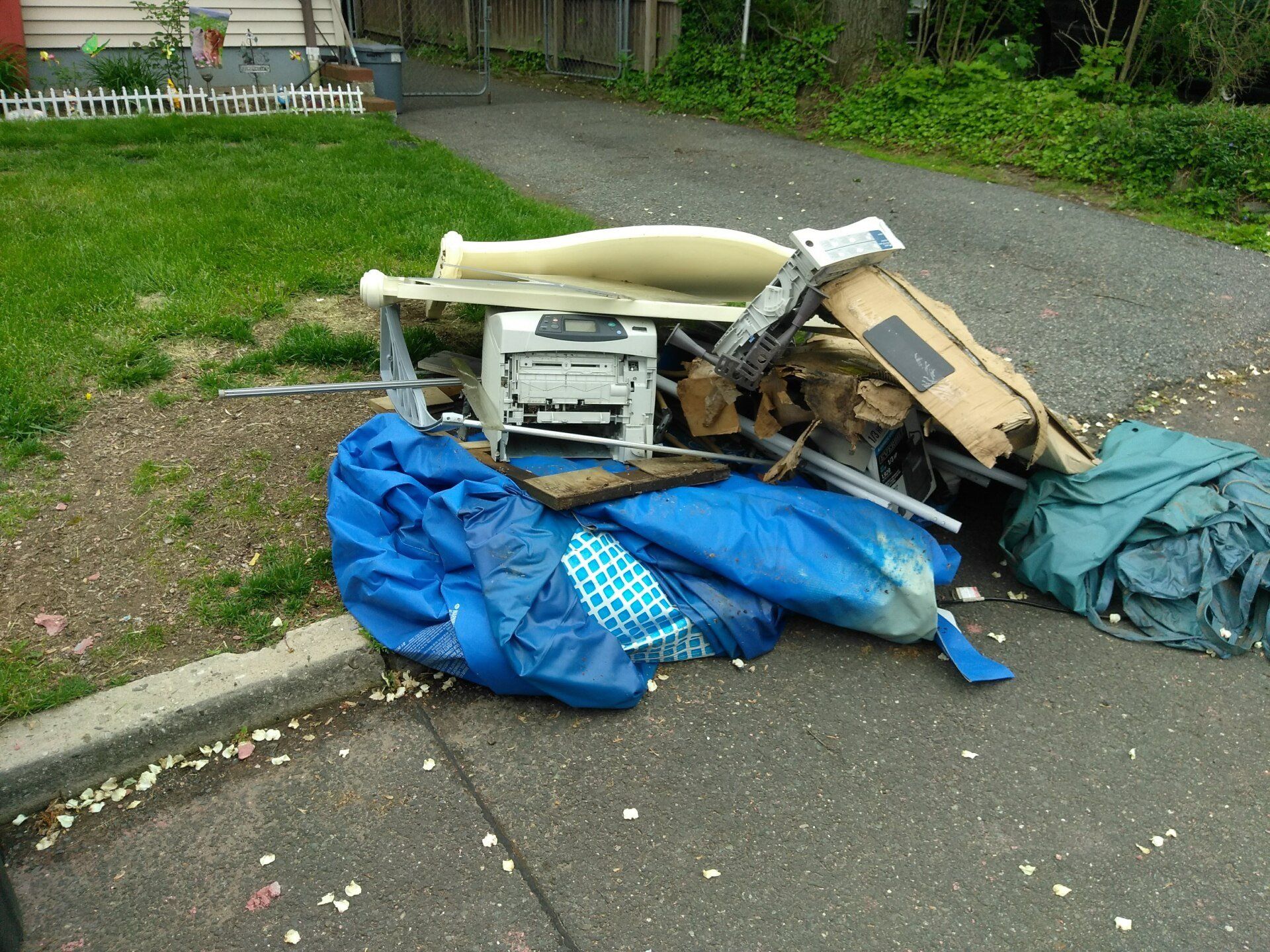 A pile of trash is sitting on the side of the road.