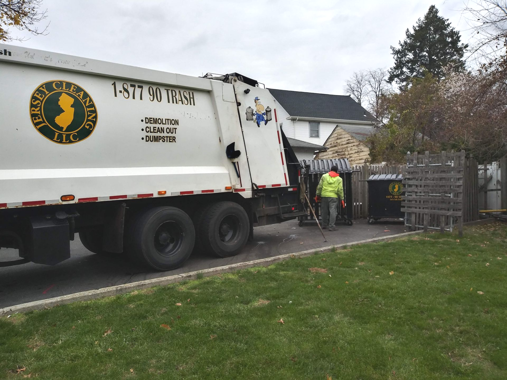 A garbage truck is parked in front of a house