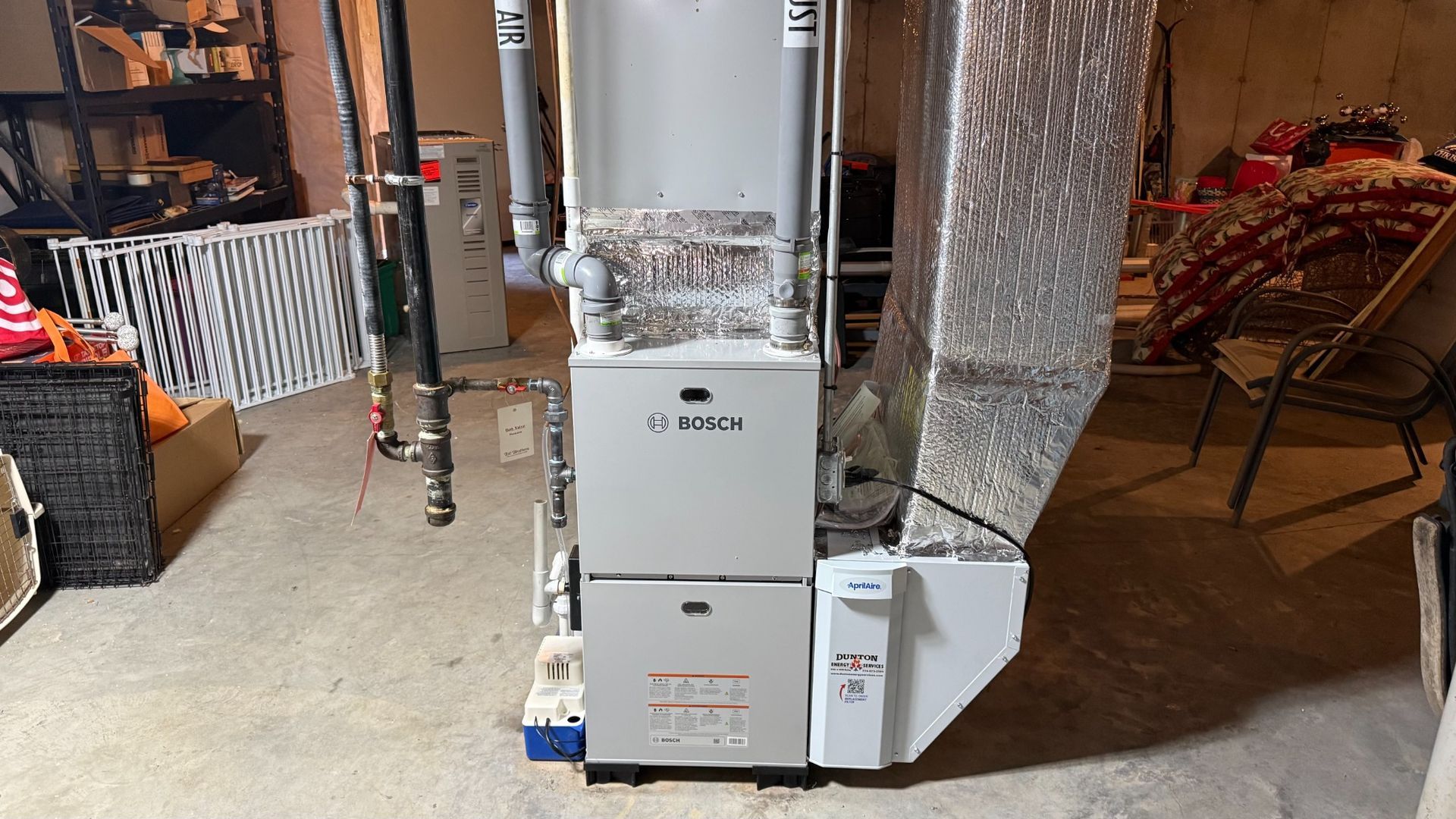 Bosch furnace and white water heater in an unfinished basement utility area