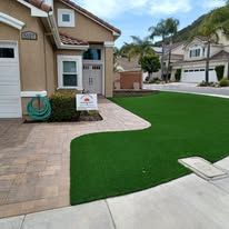 A house with a lush green lawn in front of it.