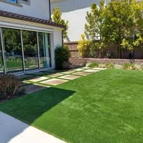 There is a large lawn in the backyard of a house.