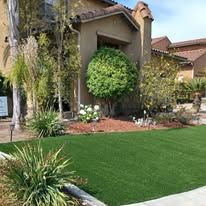A house with a lush green lawn in front of it.
