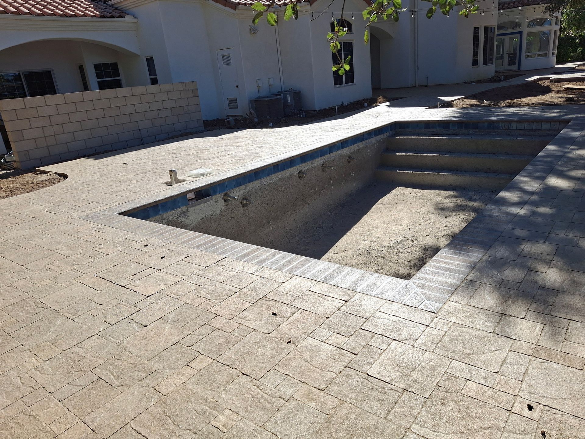 A swimming pool is being built in front of a house.