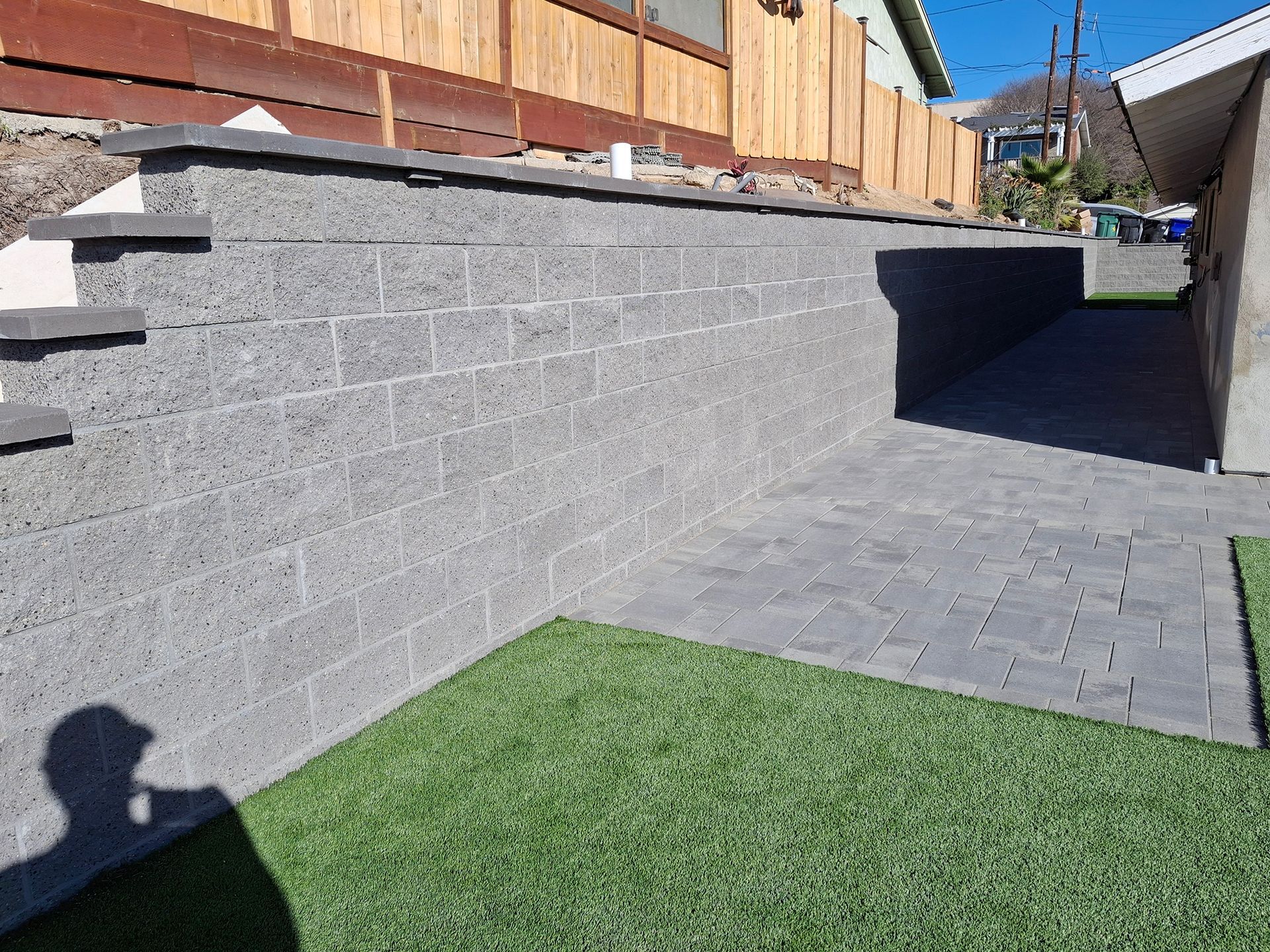 There is a brick wall in the backyard of a house.