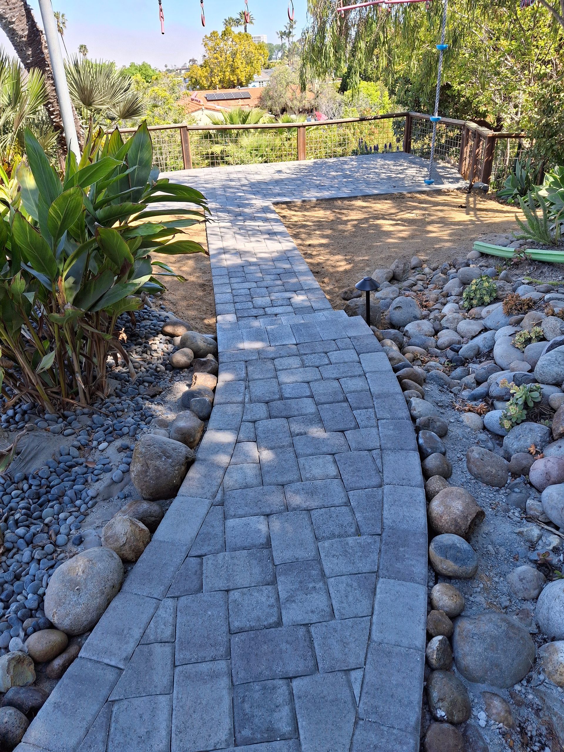 A stone walkway surrounded by rocks and plants in a garden.