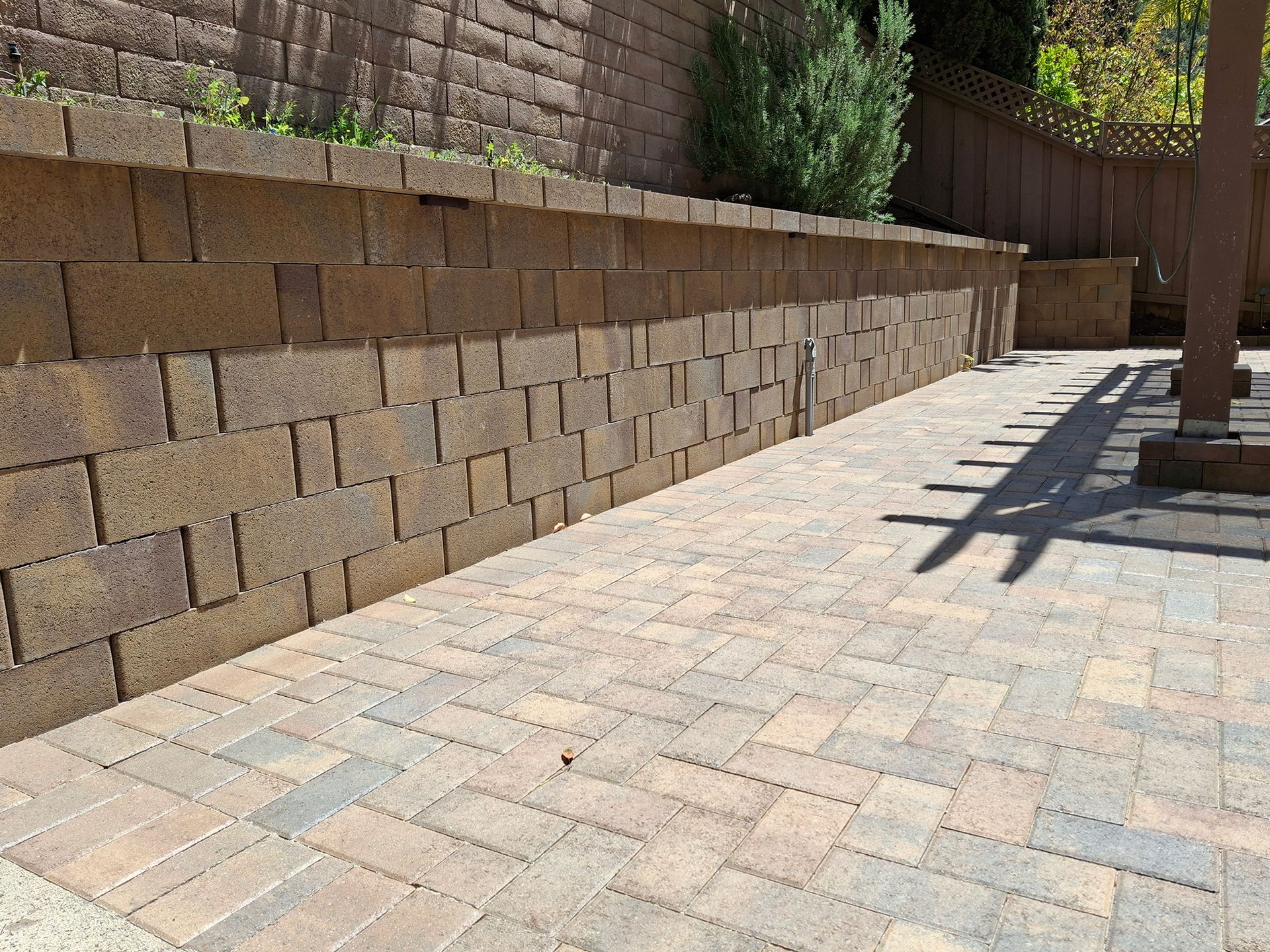 A brick wall with a patio in front of it.