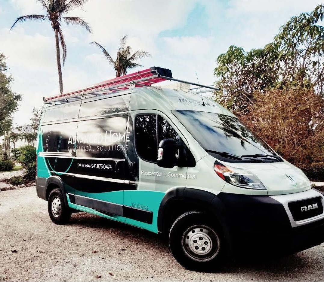 White and teal cargo van parked on a dirt road with palm trees in the background