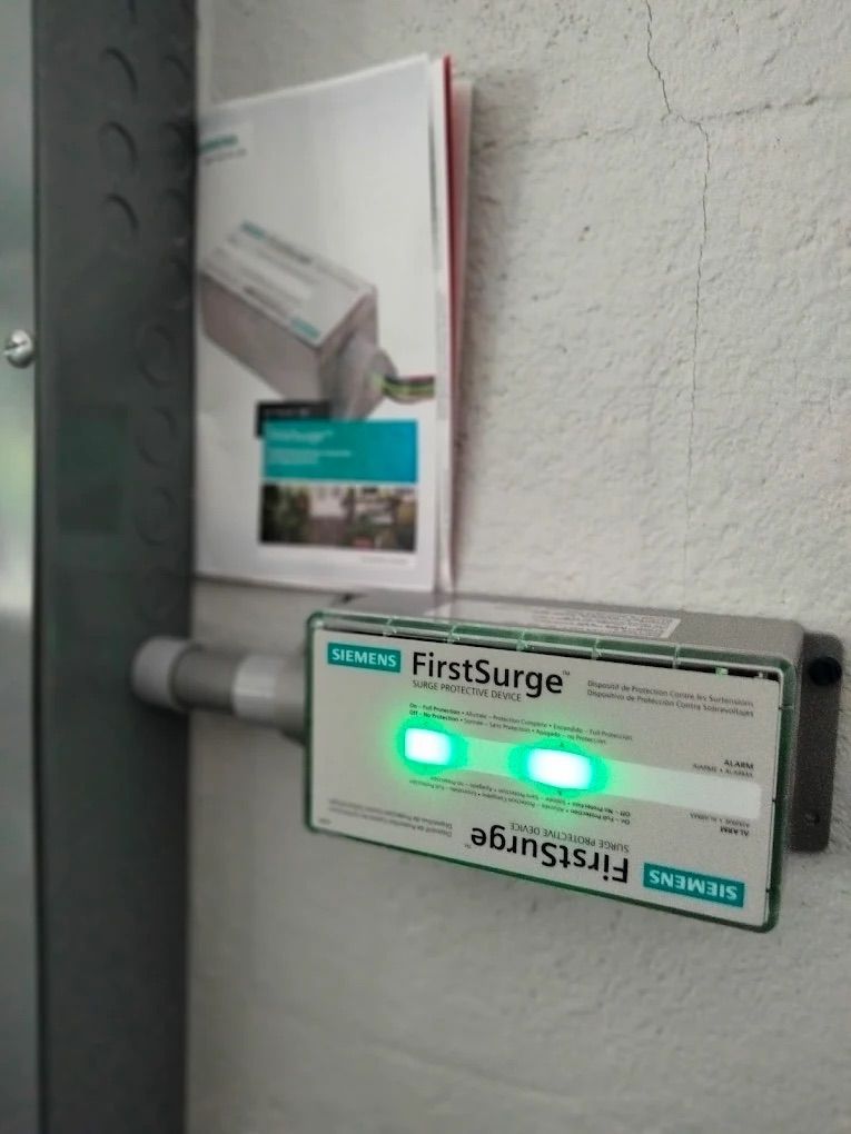 FirstSurg biomedical device with green indicator lights mounted on a wall in a clinic hallway