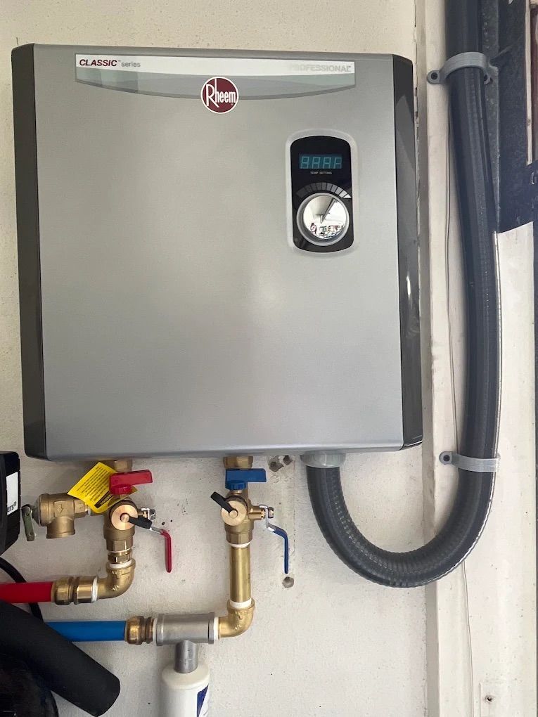 Gray wall-mounted water heater with pipes and valves in a utility room