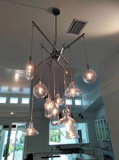 Modern hanging chandelier with exposed bulbs in a bright kitchen or dining space