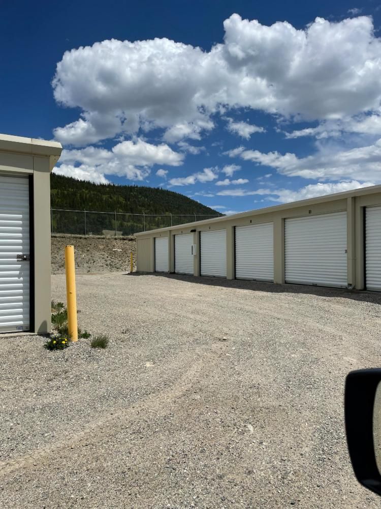 A row of white garage doors are lined up in a parking lot