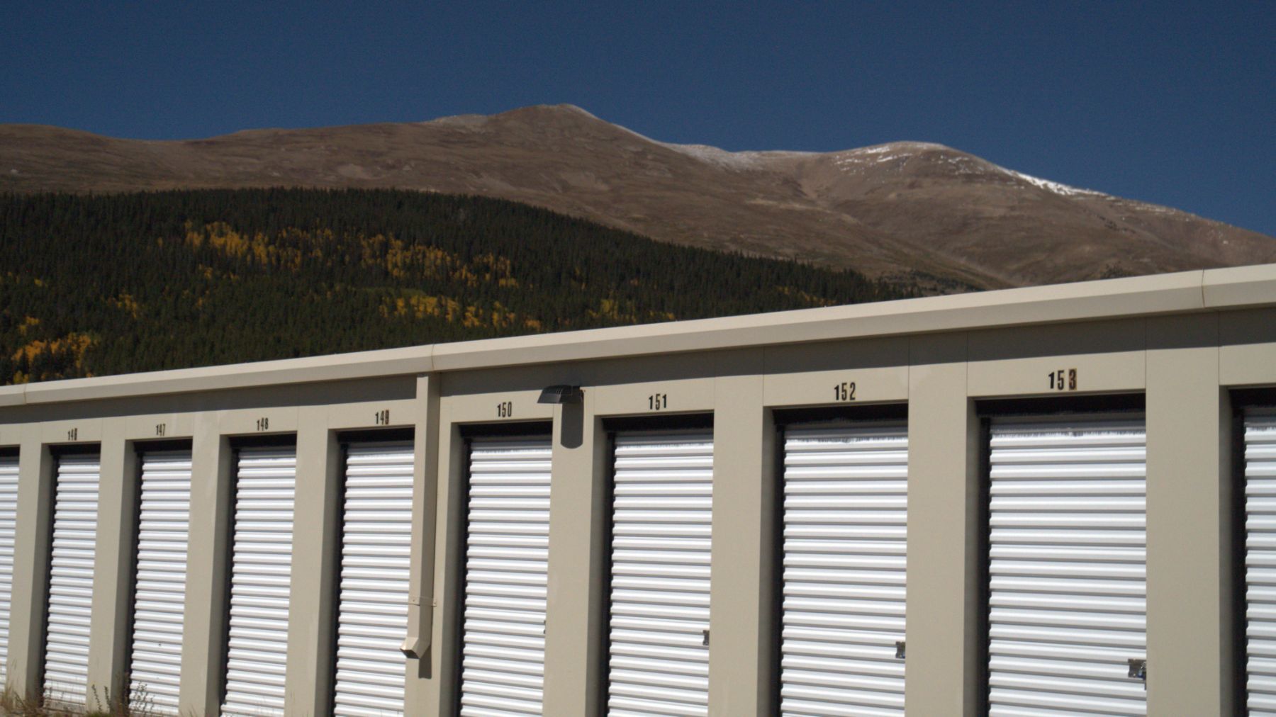 A row of storage units with mountains in the background